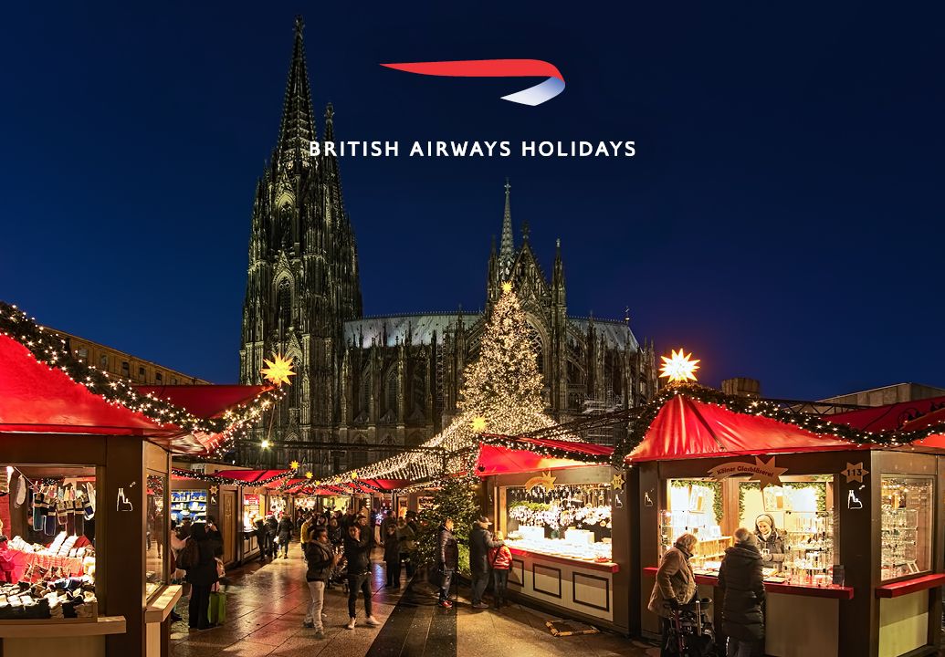 A Christmas market at dusk with the British Airways Holidays logo